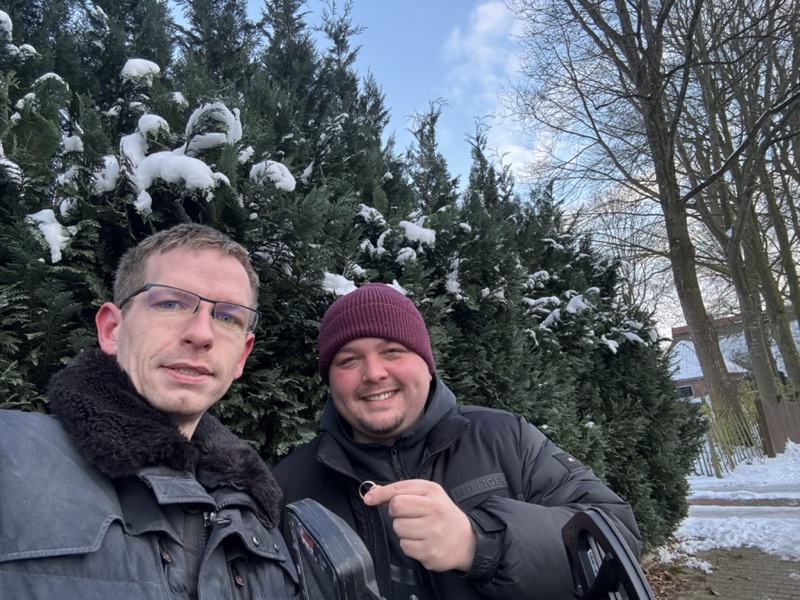 Ringsucher sucht mit dem Metalldetektor im Schnee nach einem verlorenen Ehering